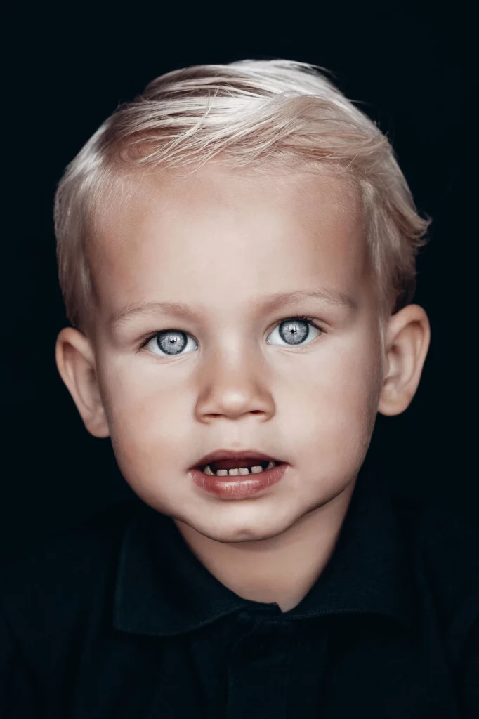 Portretfoto van 2 jarige jongen die in de lens kijkt