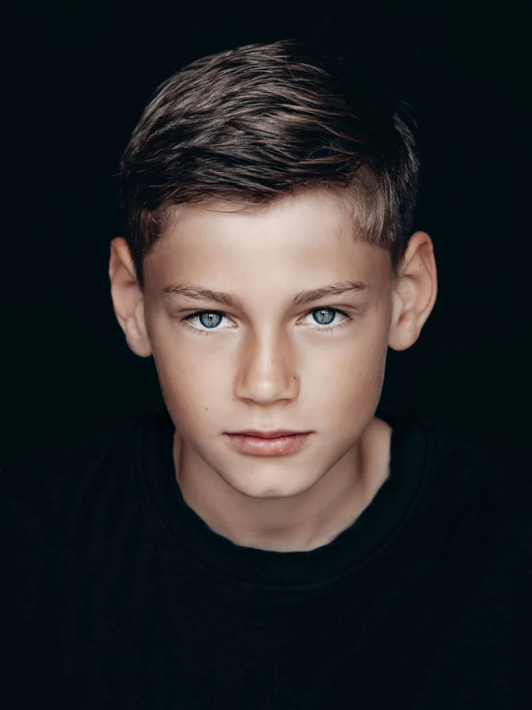 Een portretfoto van een jongen die in de camera kijkt
